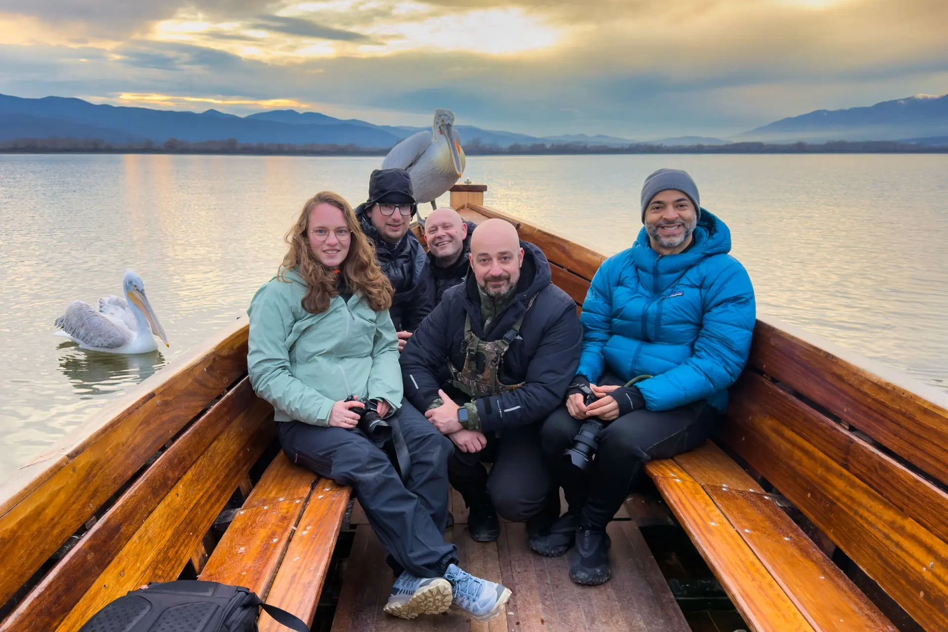 Five photographers in a boat photographing Dalmatian Pelicans at Lake Kerkini during The Kingdom of the Pelicans workshop